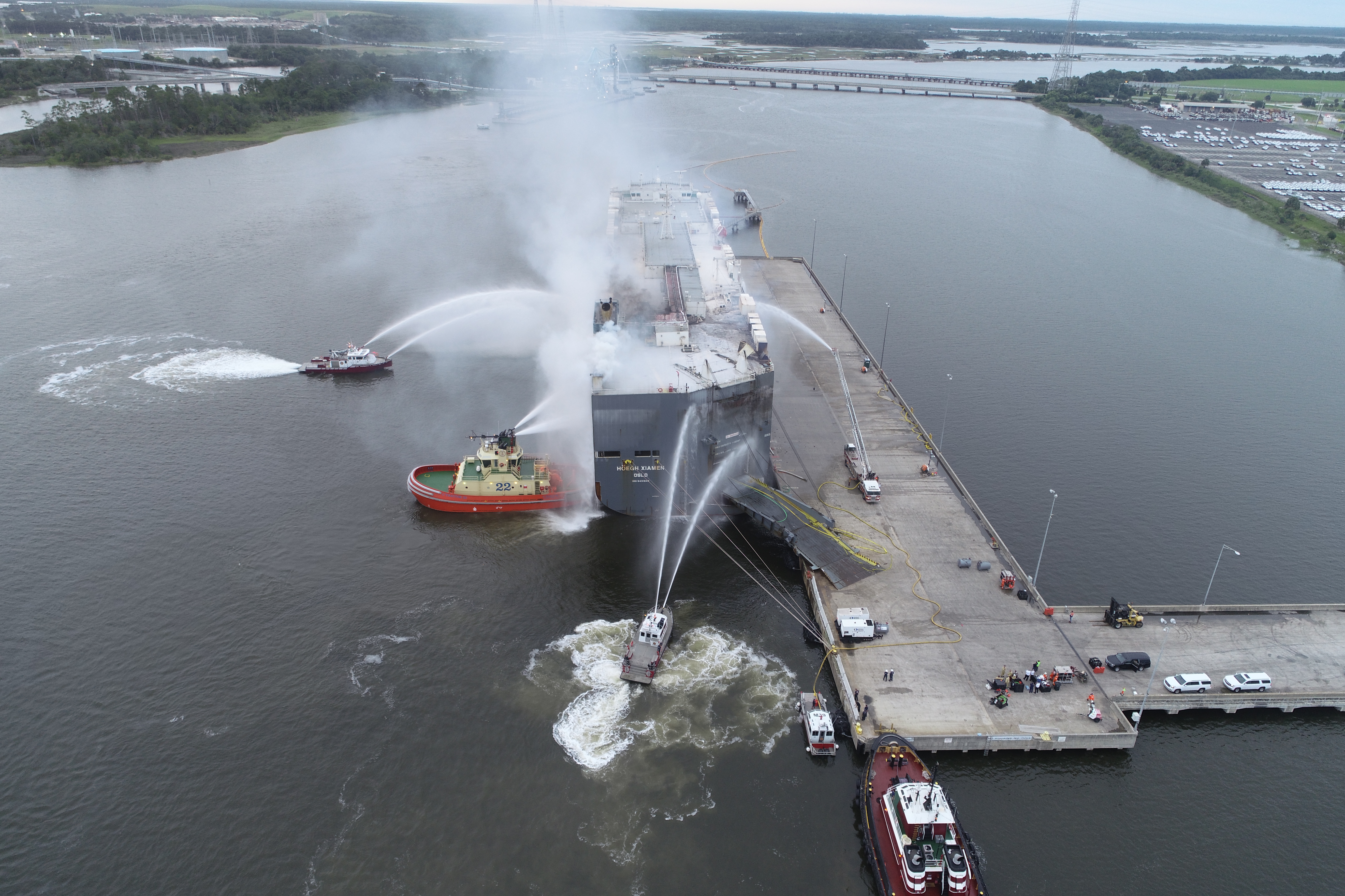 Aerial shot of several fire-rescue boats spraying the vessel MV HOEGH XIAMEN with water